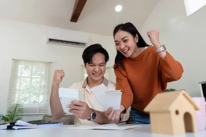 Photo d'un couple de jeunes asiatiques, contents de bénéficier d'une aide suffisante. Ils ont voulu calculer les APL.