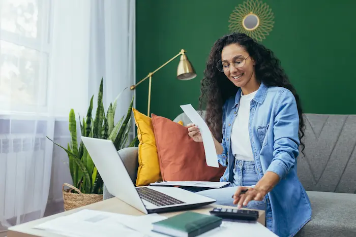Photo d'une femme, ravie de voir qu'elle est éligible aux aides au logement étudiant disponibles en 2025