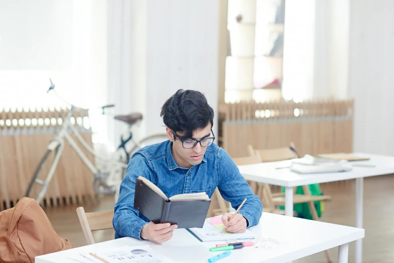 résidence étudiante à Nantes : un étudiant dans une résidence est en train d'étudier sur son bureau. Il vit seul dans un studio.