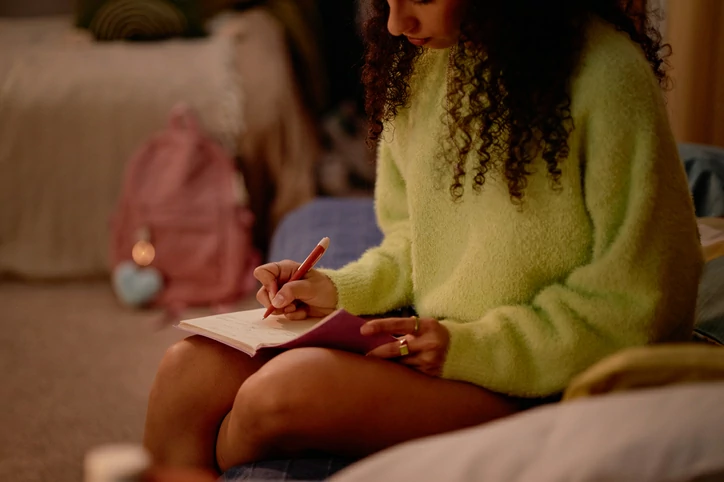 résidence étudiante à Lyon 07 : une étudiante révise dans une chambre de résidence seule.