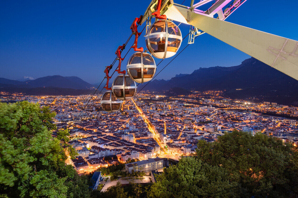 Vue aérienne sur la téléphérique et la ville de Grenoble au loin, mettant en avant le charme de la ville. Cela explique son attrait, la résidence étudiante à Grenoble est très prisée