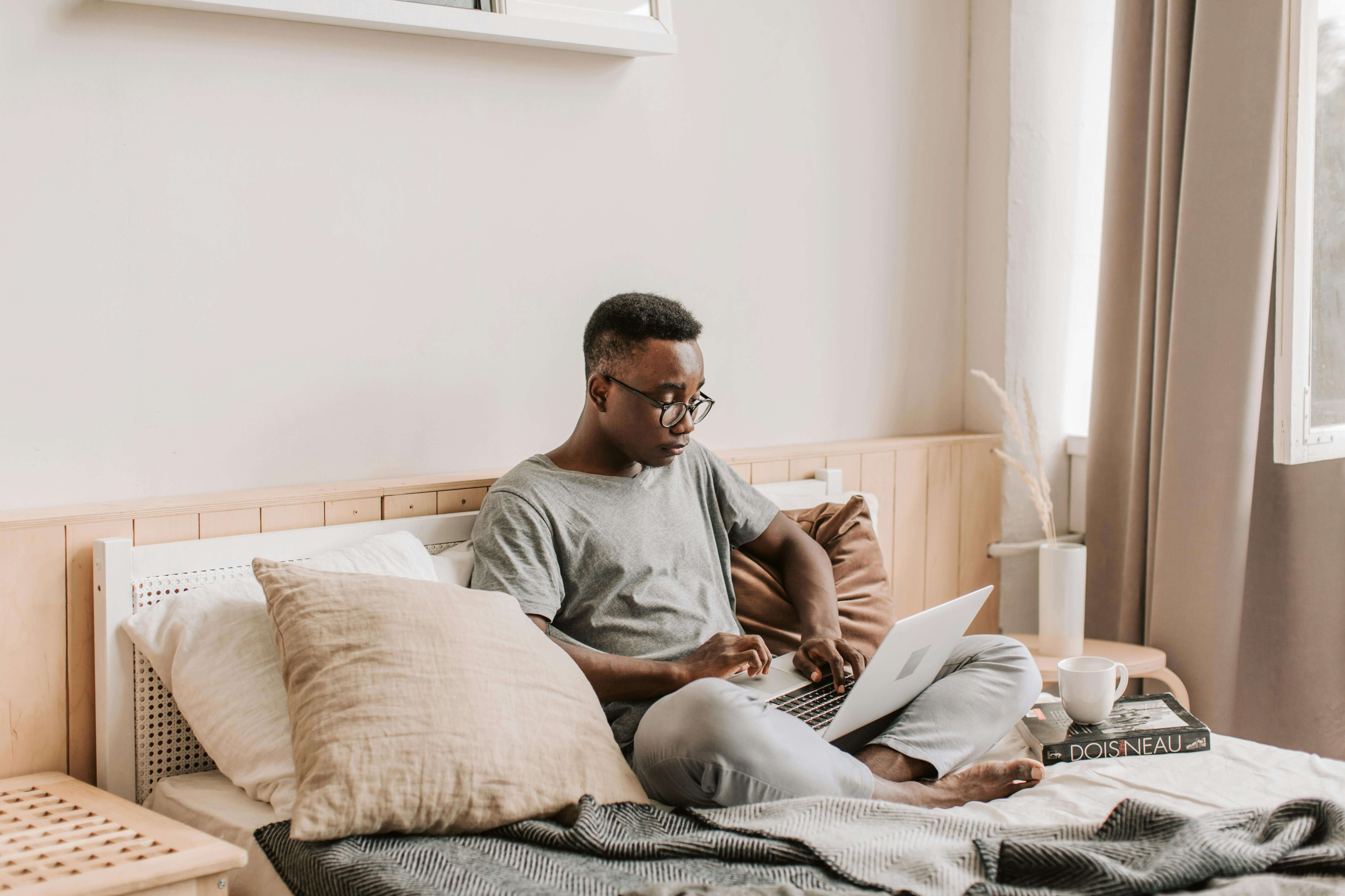 Un étudiant qui est en train d'étudier confortablement dans sa chambre. 