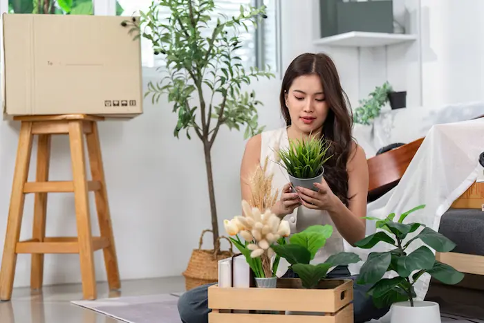 Une étudiante en train de ranger ses affaires, assise devant un carton, dans son nouveau logement étudiant Gentilly