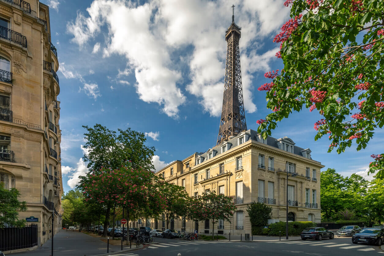 Vue sur un immeuble parisien, la Tour Eiffel est visible derrière l'immeuble. Cette image met en avant la beauté de la ville de Paris, l'immeuble évoque le charme d'une résidence étudiante Paris 13