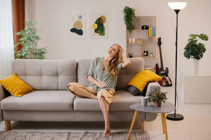 Une étudiante est assise confortablement dans son studio en location studio étudiante