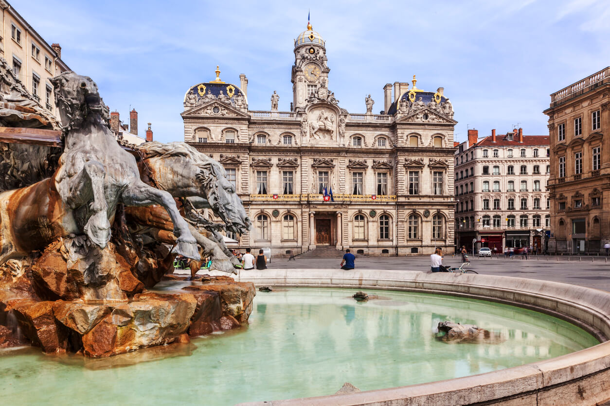 Ville de Lyon, mettant en avant la beauté de la ville. L'on voit la célèbre fontaine de Lyon et un logement où la colocation à Lyon est prisée.