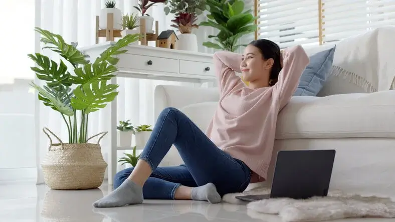 Photo d'une étudiante dans son logement étudiant à Cergy. Elle apprécie l'ambiance zen de son salon en colocation à Cergy.