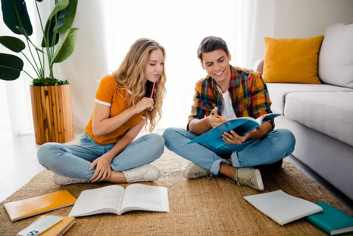 Deux étudiants assis dans le salon de leur studio, logement étudiant trouvé sur ImmoJeune, dans un quartier étudiant réputé et proche du campus