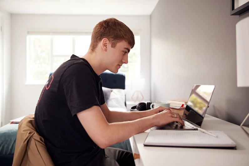 résidence étudiante à Besançon : un étudiant est en train de réviser ses cours avant les examens. Routine universitaire. Logement étudiant.