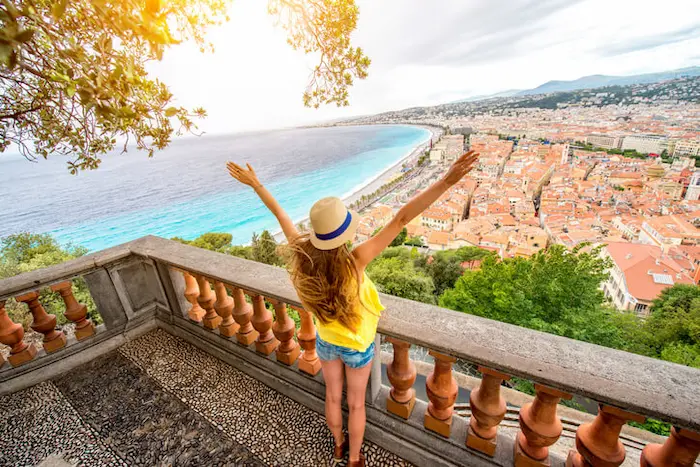 Photo d'une étudiante avec vue sur la ville de Nice. Cette photo met en avant la splendeur de cette ville à l'allure méditerranéenne et l'attractivité de la location étudiant à Nice.