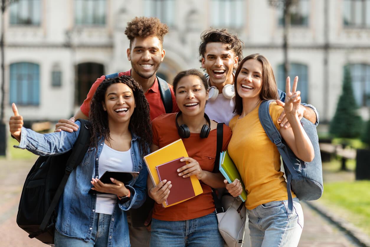 Des jeunes étudiants souriants, à l'extérieur du campus. Cette photo met en avant la cohésion dans la vie quotidienne en résidence étudiante à Marseille. 