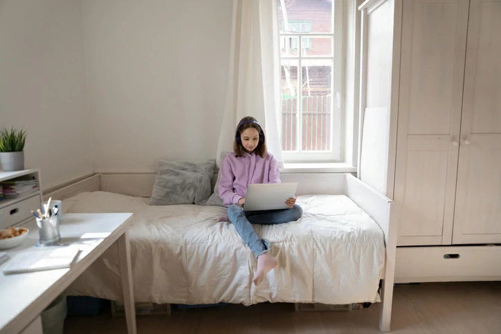 colocation à Issy-les-Moulineaux : une étudiante dans sa chambre avec un ordinateur.
