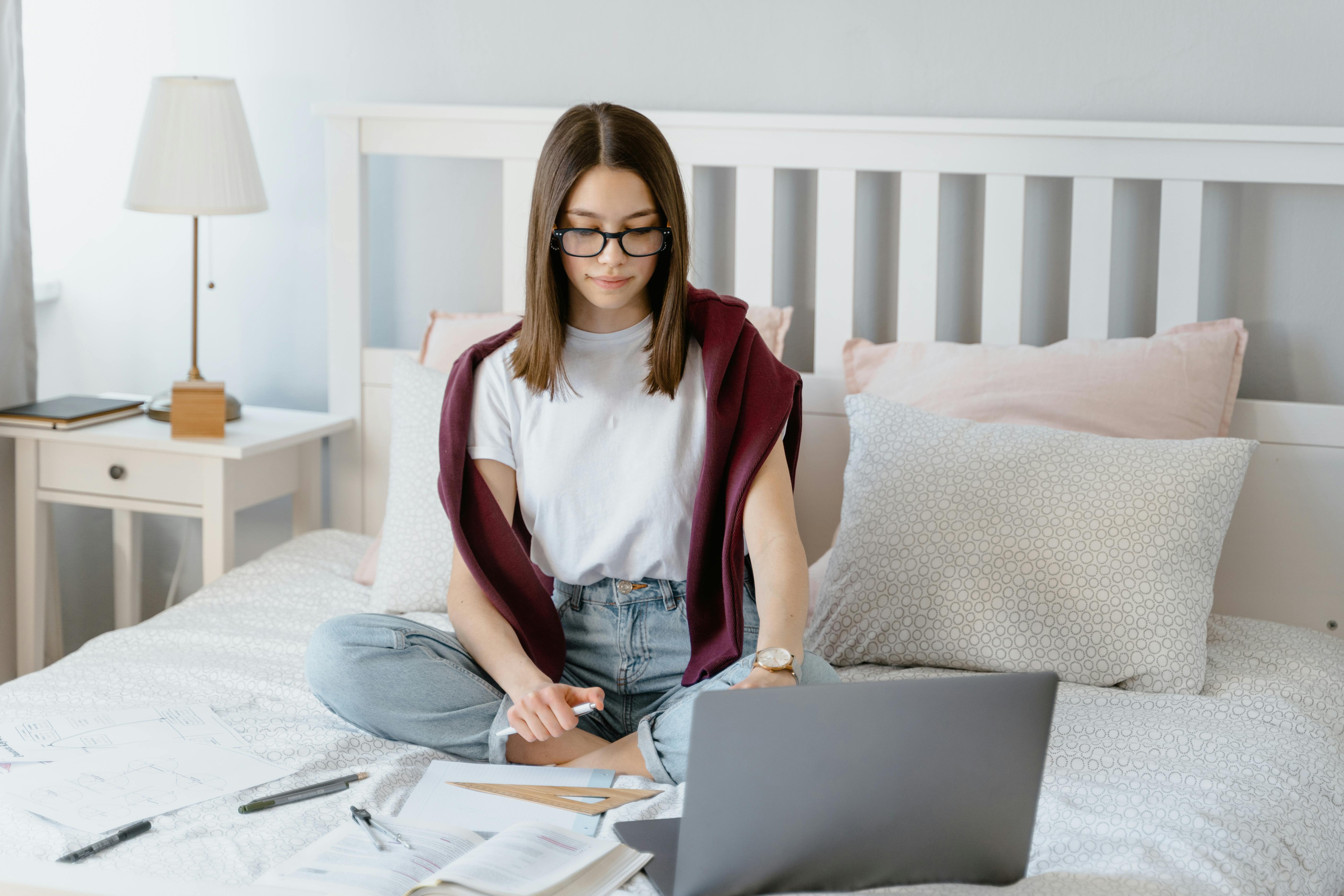 Une étudiante qui est en train de réviser dans sa propre chambre. Elle bénéficie d'une grande intimité i